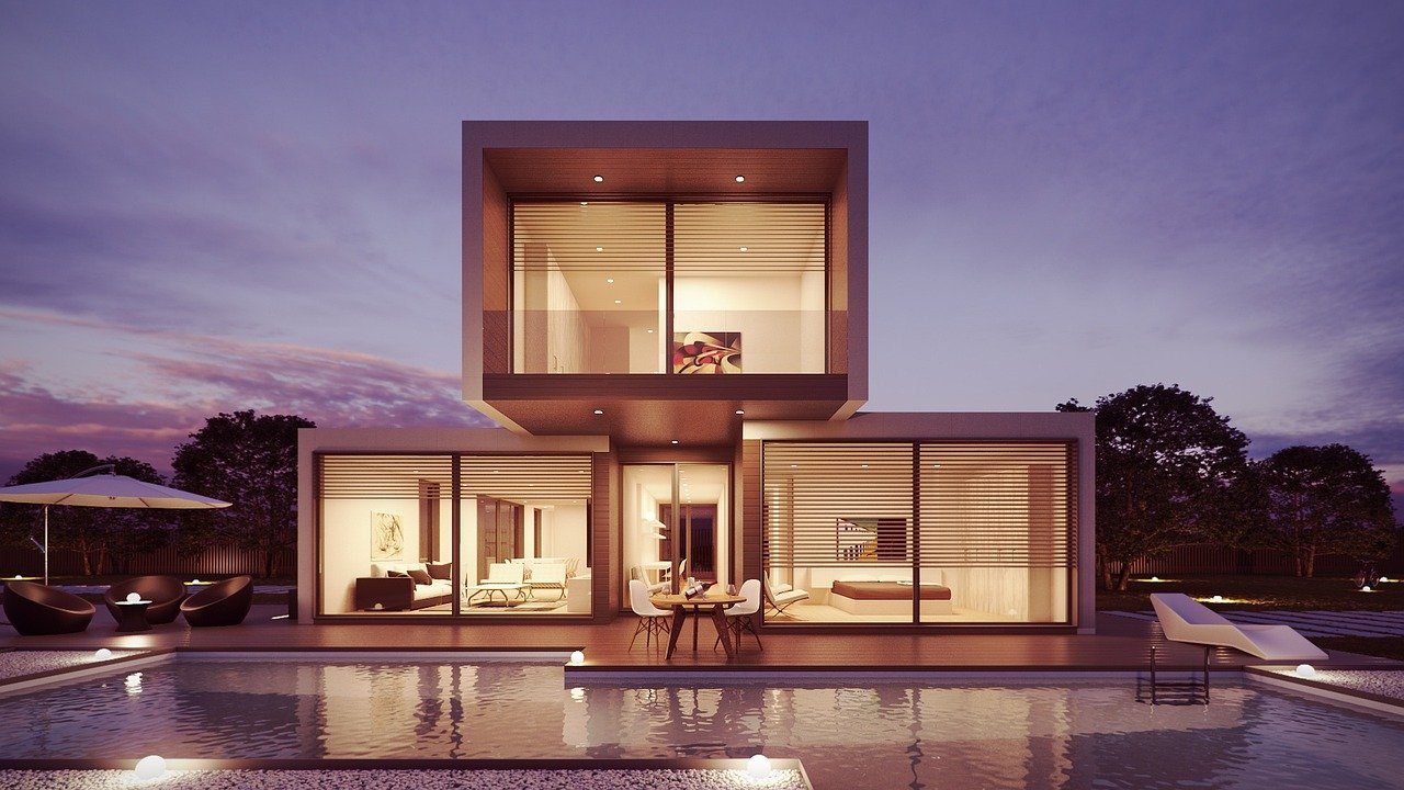 Contemporary home at dusk, warm interior light and pool reflecting the sky