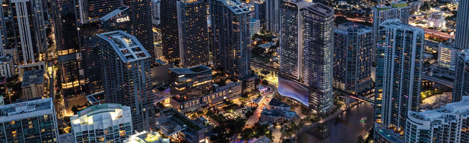 Brickell at night with the tower on the Miami River