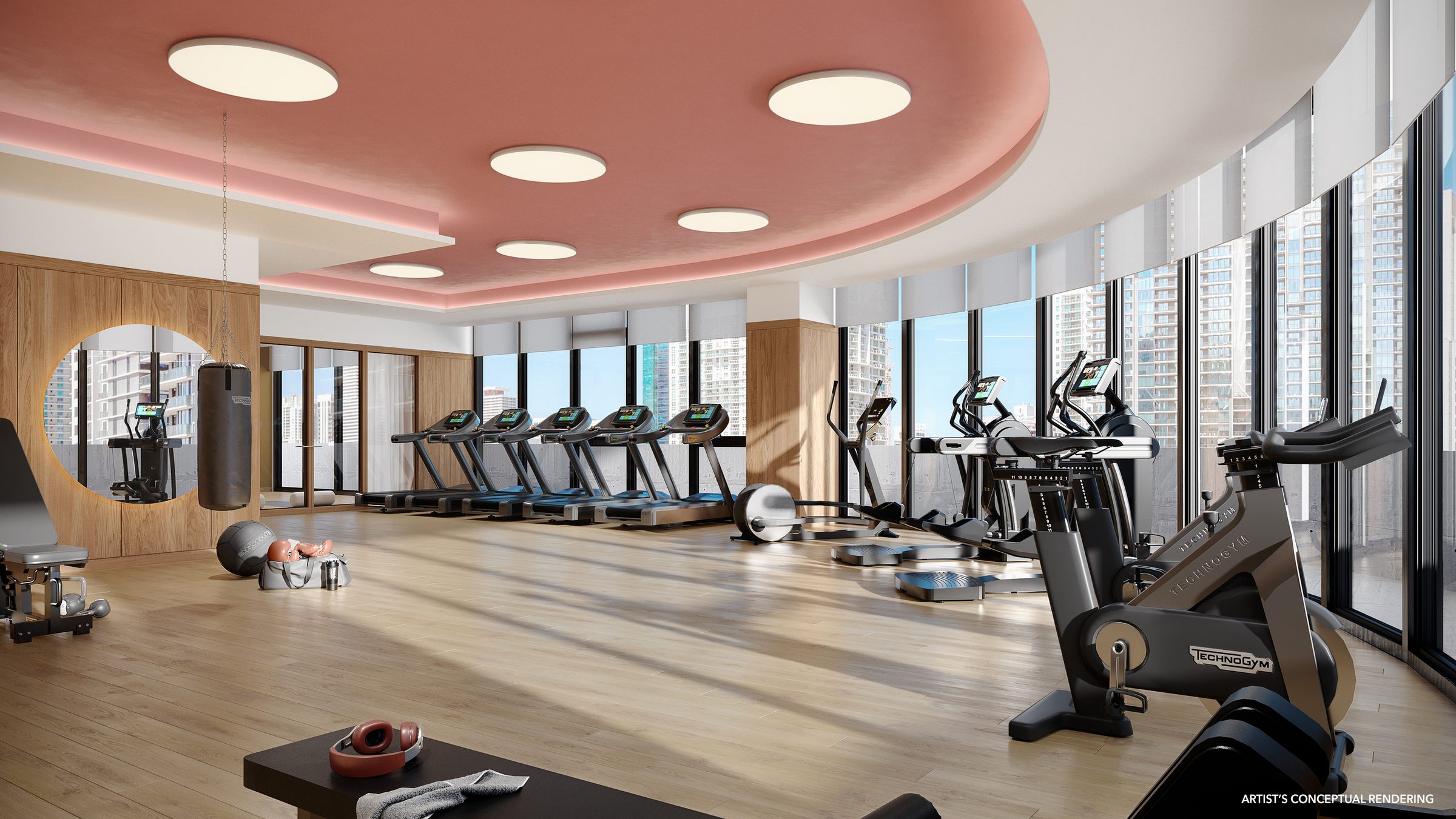 The fitness center with Technogym equipment, a pink ceiling and floor-to-ceiling windows